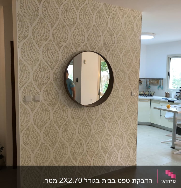 קיר עם טפט דוגמת עלים ומראה עגולה
